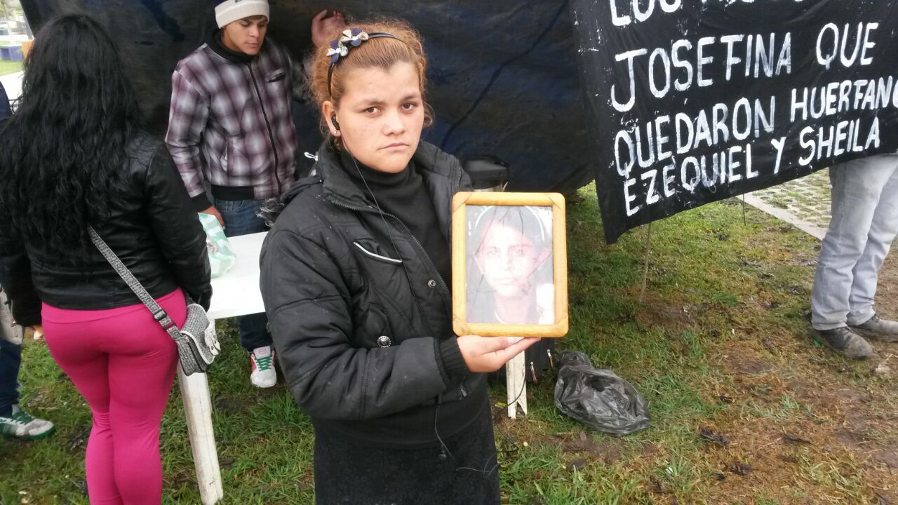 La hermana de Josefina, sosteniendo un retrato de quien fuera asesinada teniendo 17 años y dos hijos.
