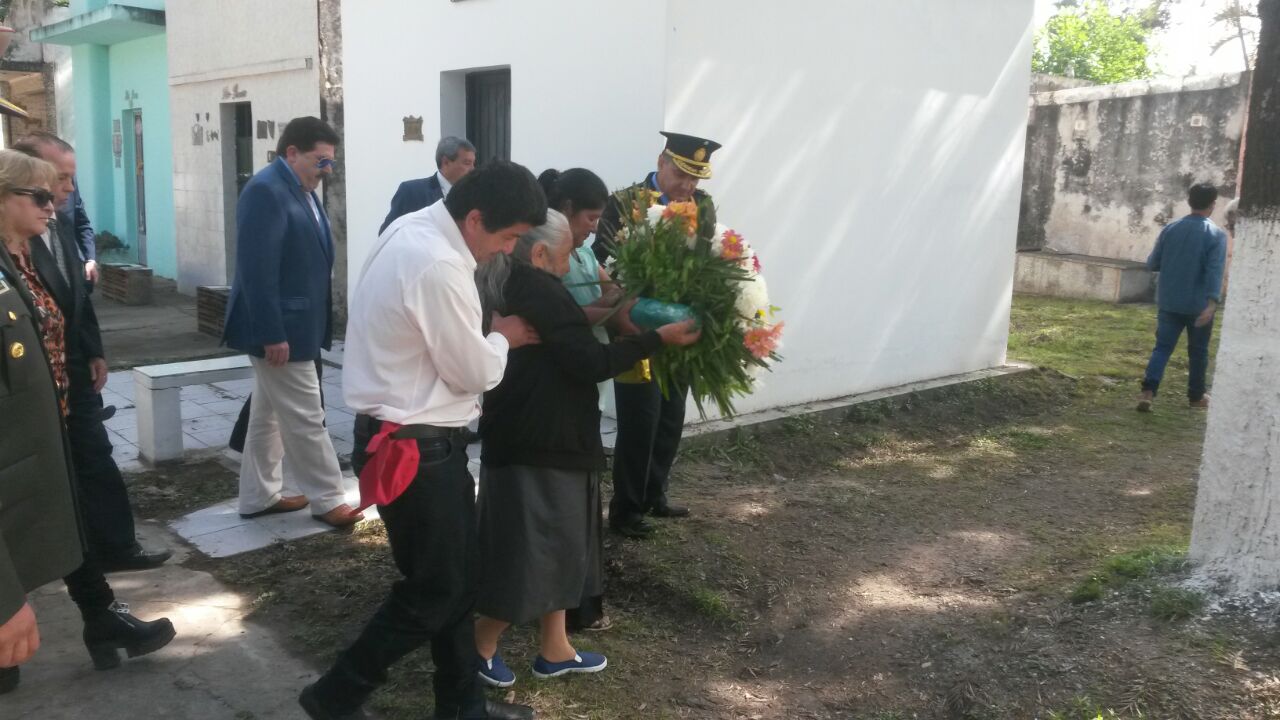 La madre del soldado caído llevando la ofrenda floral para su hijo.